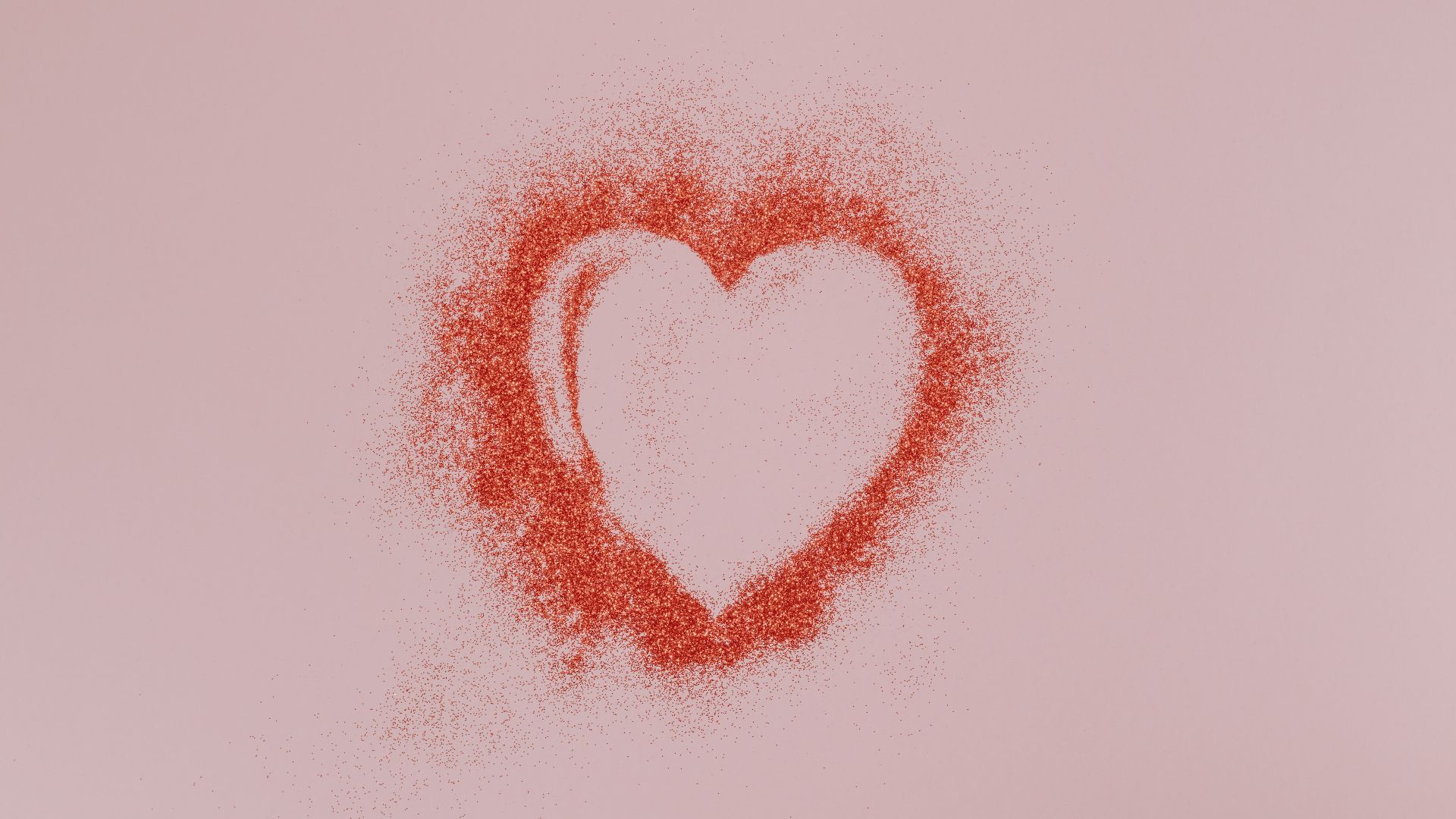 pink background with glitter in the shape of a heart