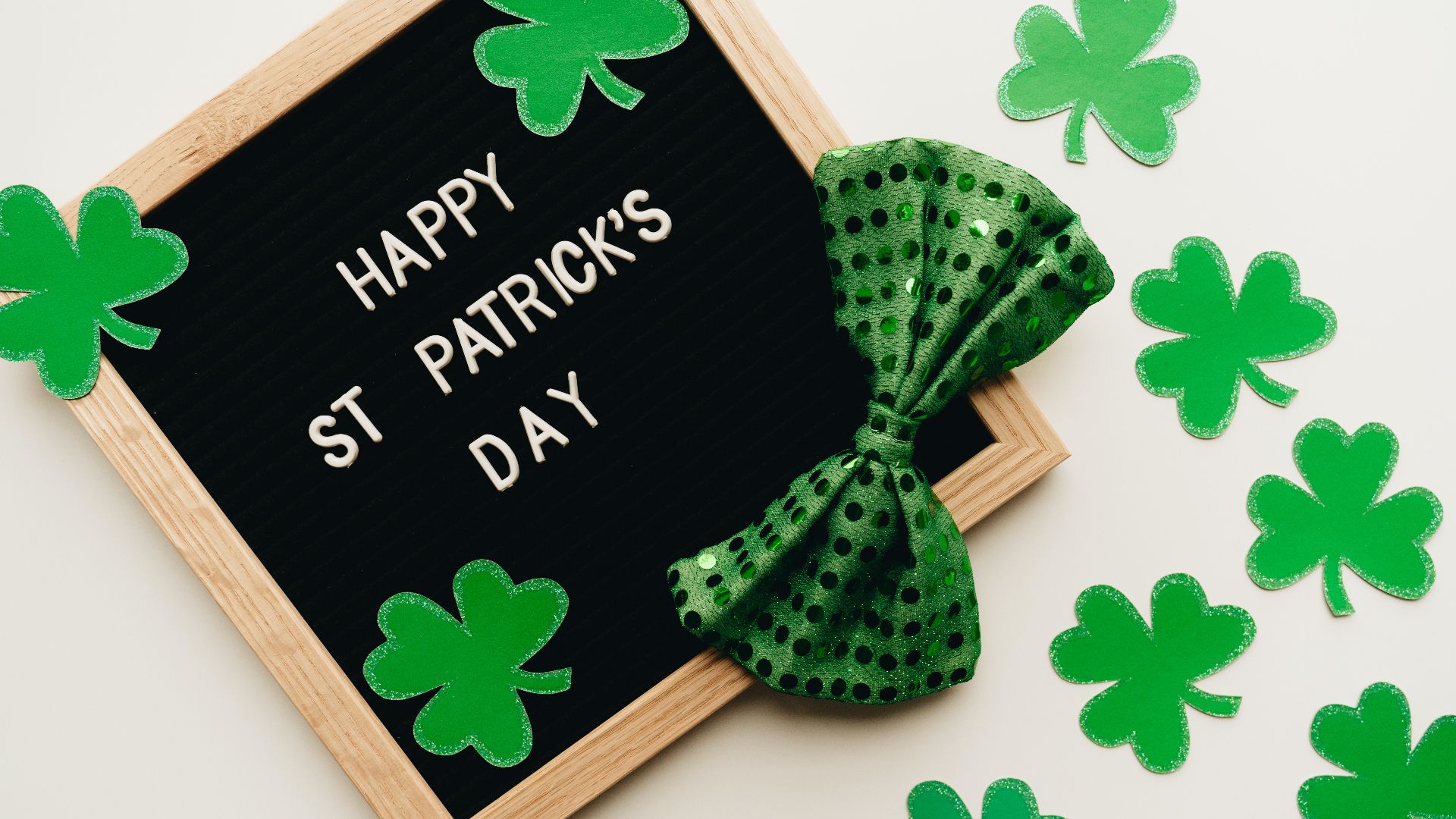 a letter board with St. Patrick's day spelled out next to green paper shamrocks