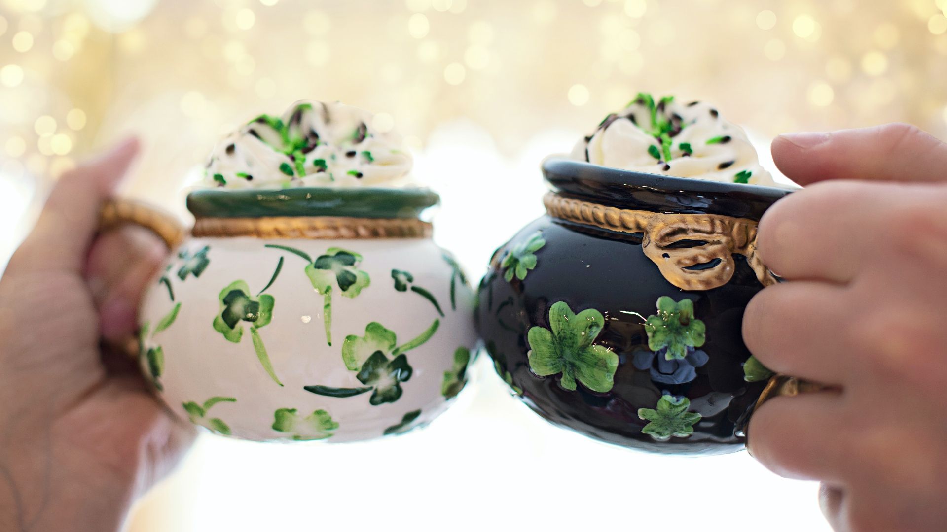 two people cheering shamrock decorated mugs