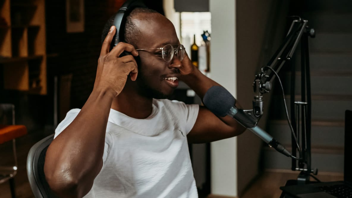 Photograph of a man recording a voice over in his home studio.